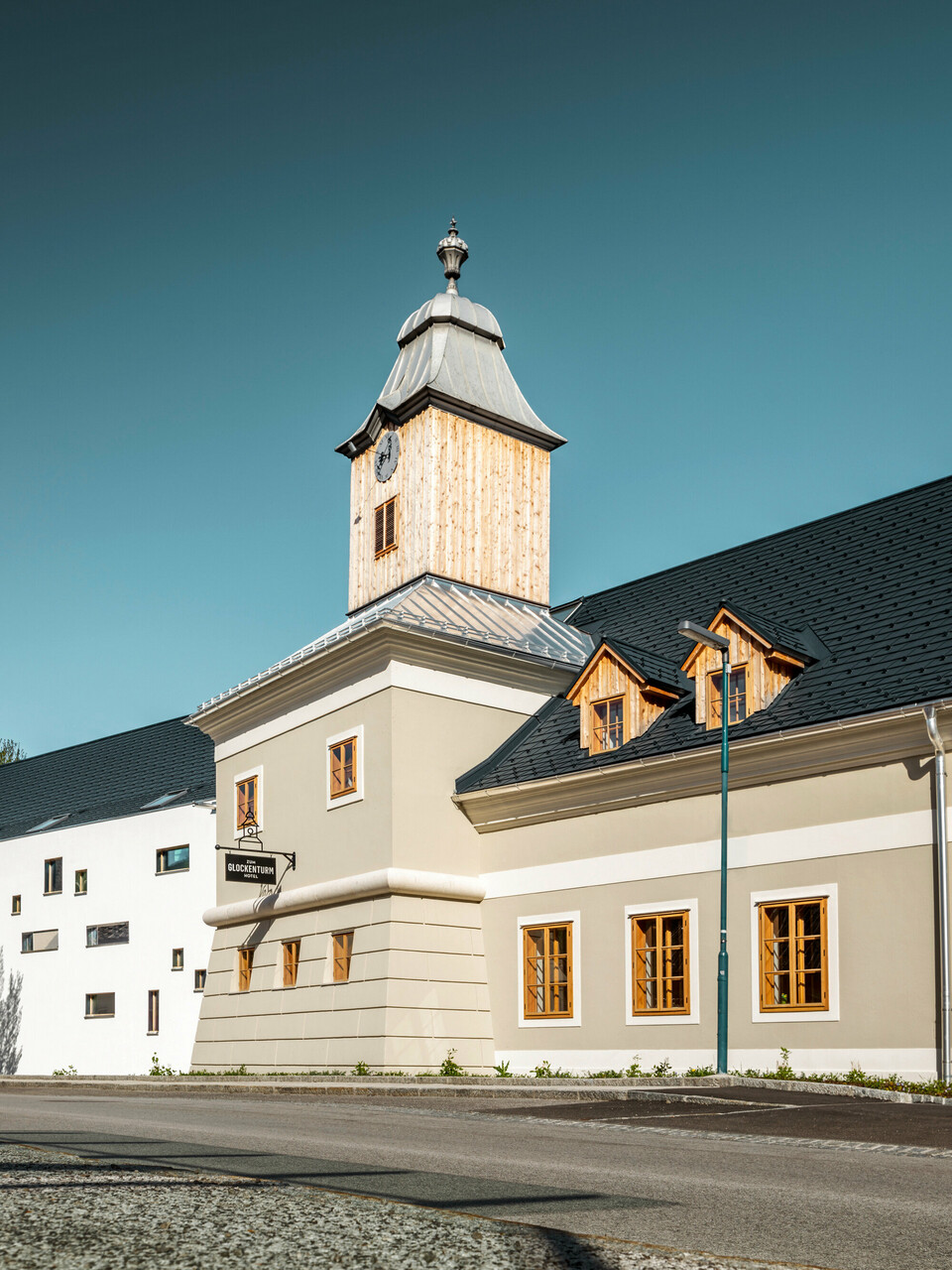 Das Dach des Hotels Glockenturm in Marktl bei Lilienfeld wurde mit der PREFA Dachschindel in P.10 Anthrazit verkleidet. Das PREFA Dachentwässerungssystem des Gebäudes ist in Naturblank gehalten. Unweit vom Hotel Glockenturm liegt das Leopold - unser Wirtshaus. Das Restaurantgebäude wurde ebenfalls mit PREFA Produkten eingedeckt.