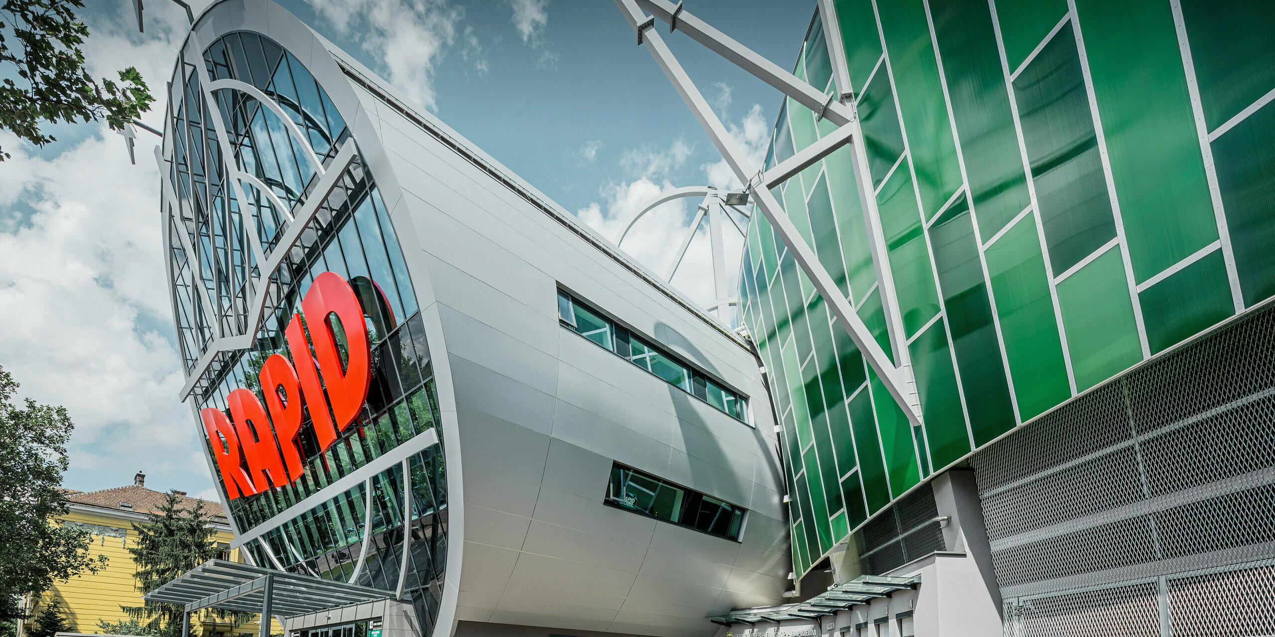 Das Allianz Stadion des SK Rapid Wien, gekennzeichnet durch eine imposante Röhre im Eingangsbereich. Die Röhre misst einen Durchmesser von 20 Meter. Die spektakuläre Fassade der Röhre ist mit PREFA Aluminium Verbundplatten in Silbermetallic verkleidet. Die Aluminiumhülle verleiht der Struktur ein futuristisches Design, das Technologie und Sportgeist in harmonischer Architektur vereint.