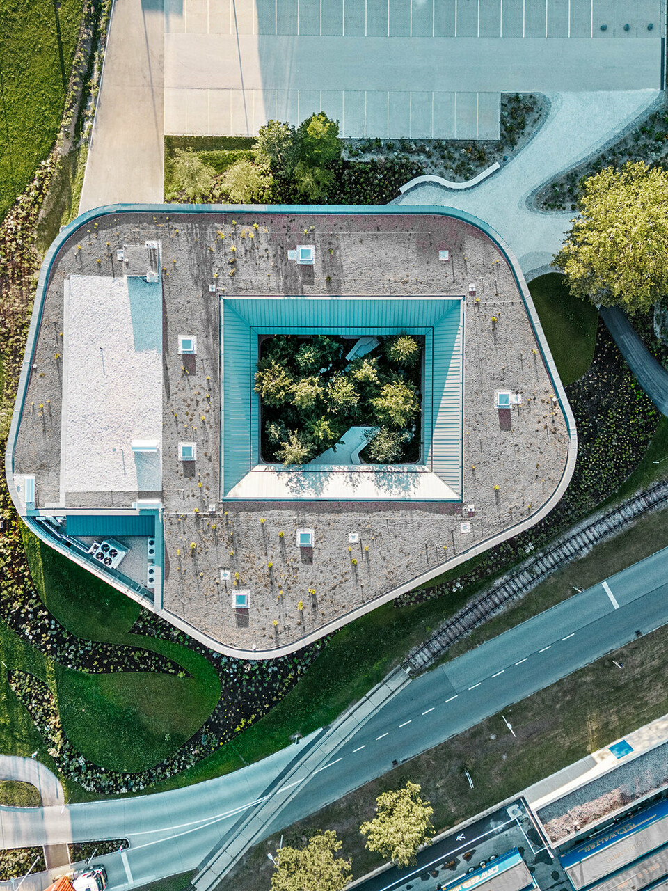 Das Restaurant Walters im Business-Park der WALTER GROUP aus der Vogelperspektive; der Wald im Atrium sowie die umliegenden Straßen sind im Blick.