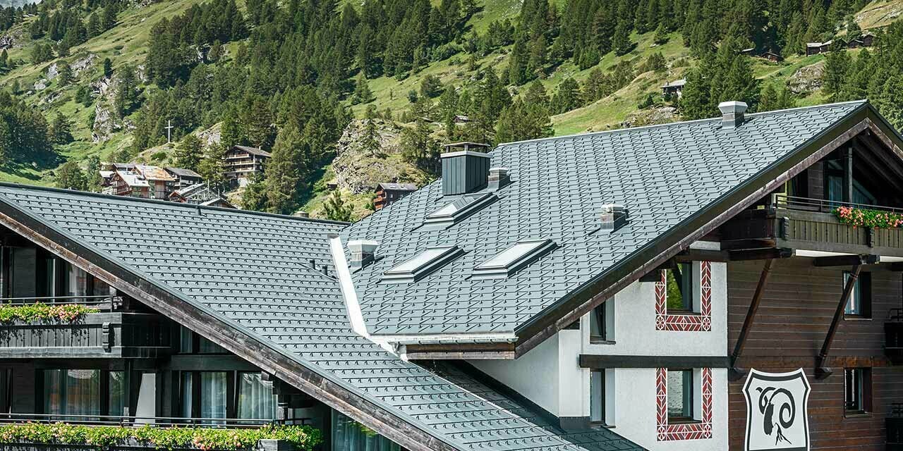 Hotel Alpenhof Zermatt, háttérben a Matterhornnal, erkélyekkel, sötét fa homlokzattal és antracit színű PREFA alumínium fedéssel